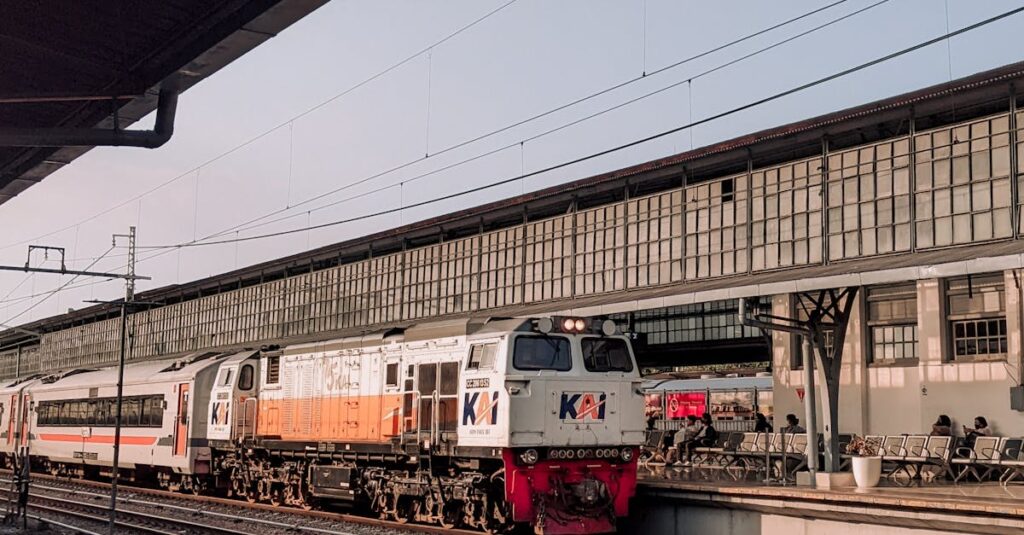 Image of a train at Malang station, East Java, Indonesia. Clear sky and platform visible.